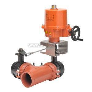 A large flow control setup featuring a vertical orange electric actuator with a side hand crank mounted on a metal bracket above a horizontal orange pipe section with black grooved couplings and a linkage connecting the actuator to the valve.