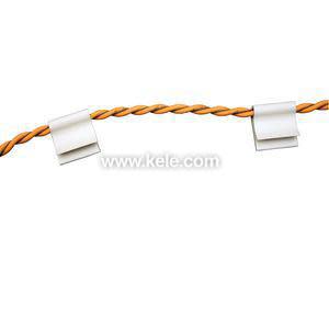 Set of small white cable clips clamping onto an orange twisted pair of wires