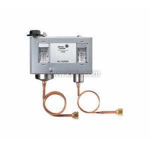 Rectangular Johnson Controls Penn dual pressure control unit with two clear gauge windows, a black adjustment knob on top, and two coiled copper capillary tubes with brass fittings extending below.