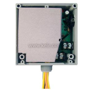 Square box with cover removed, showing internal electronics covered by a beige shield and yellow wire bundle.