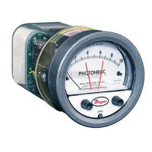 Cylindrical Photohelic gauge with clear casing showing internal electronics and round analog dial front with two knobs