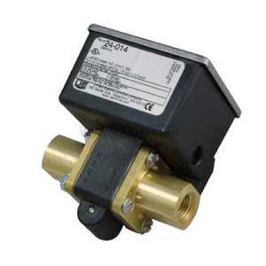 Brass T‑shaped flow switch with two threaded ports and a black rectangular housing with white label on top.