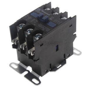 Black rectangular device with rows of terminal prongs mounted to a flat metal bracket.