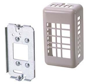 Beige plastic cage with slotted sides attaches to a rectangular metal bracket to cover a wall thermostat.
