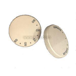 Two beige round thermostat dials with serrated edges printed with numbers 50 through 90 and arrows indicating 'Warmer' and 'Cooler'.