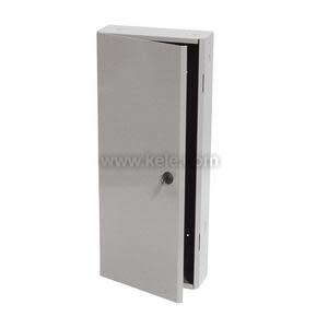 A slender upright grey steel cabinet with a hinged door slightly opened; the door has a small round key lock and the inside is empty and dark, placed on a plain white background