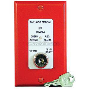 Red rectangular wall plate with a central white panel labeled for duct smoke detector status, featuring a key switch and an accompanying silver key.
