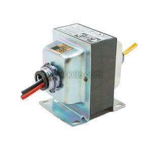 Small metal transformer with dark core, silver housing, flanged base and two pairs of colored wires emerging from front and rear.