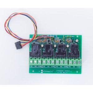 Small green circuit board featuring four black relays and a bundle of colored wires with a connector.