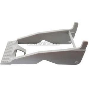 Photograph of a light grey plastic extraction lever with a ridged foot and hook‑shaped ends, used to extract or install electrical components.