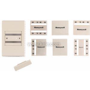 An assortment of beige thermostat housing parts, including a rectangular cover and several interchangeable plates with printed temperature scales.