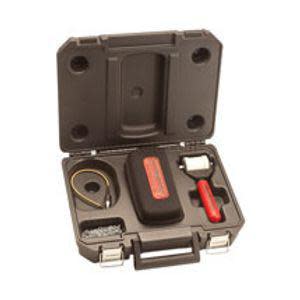 An open hard‑shell case reveals a collection of compact tools and accessories fitted into molded slots, including a red‑handled tool and a coiled cable.