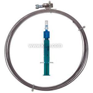 Coiled shiny metal tube with an orange plastic block at one end; a blue syringe tool lies beside it.