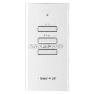 A slim white wall‑mounted control panel with three stacked rectangular buttons labeled Home, Away, and Vacation, and a small green indicator light above them.