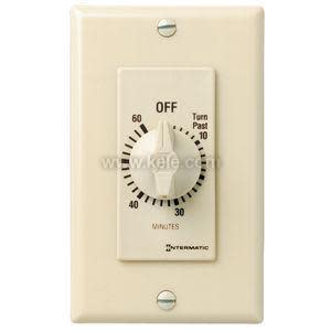 A light tan wall-mounted timer with a round dial showing up to sixty minutes and an off marking.
