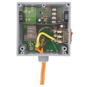Small square grey box with its cover off, revealing a green circuit board, a rectangular transformer, a relay and an orange cable coming from the bottom.