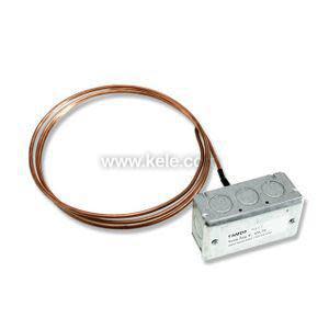 Long coiled copper tube attached to a small grey box with knockouts