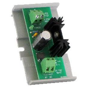 Small green circuit board on a grey mount featuring a large black capacitor, black heat sink and green screw terminals