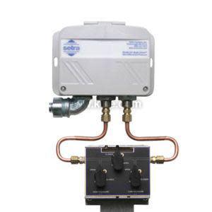 Grey rectangular pressure transmitter attached to three copper tubes and black three‑valve manifold