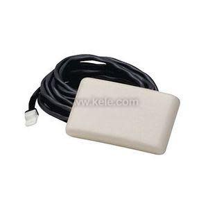 A small cream-colored rectangular plastic unit attached to a coiled black cable ending in a white connector.