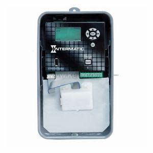 Programmable timer in a gray box with a screen, buttons and a white component inside.