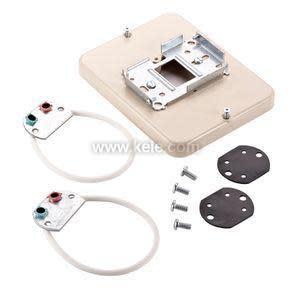 A beige mounting plate accompanied by two small wired sensor loops, screws, and two flat gaskets.