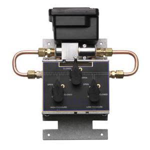 Control assembly with black actuator, copper tubing loops on both sides and knobs on front panel