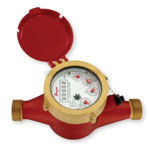 A brass and red cylindrical water meter with a circular display showing dials and numbers, protected by an open red lid, and threaded fittings on either side.