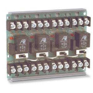 Long circuit board with rows of black relays and green terminal connectors.