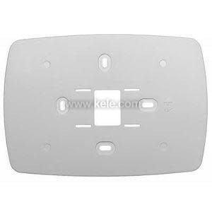 White plastic mounting plate with various slots and screw holes for thermostat wiring