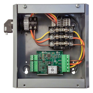 An open metal electrical box displaying a mounted circuit board, rows of fuses and multiple colored wires connected inside.