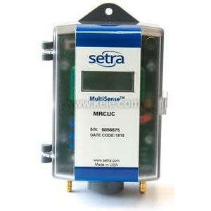 Small rectangular device with clear cover, digital display and two brass ports at bottom.