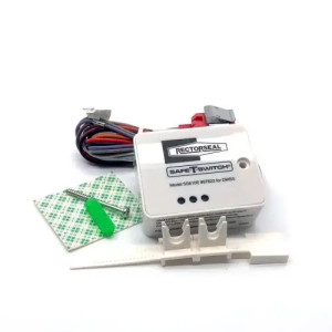 Small off‑white plastic module labeled Safe‑T‑Switch with attached multicolored wires, white bracket and green adhesive pad