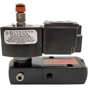 Industrial spool valve assembly with a heavy black base and a large black coil with a warning label, topped by an orange button on a metal stem.