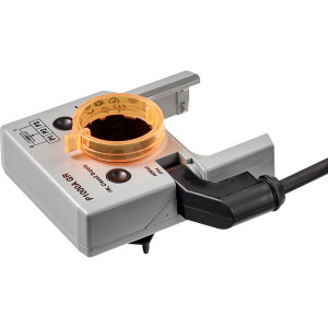 Image of a grey Belimo actuator accessory featuring an orange translucent circular clamp and a black cable attached, used to adjust or position HVAC damper actuators.