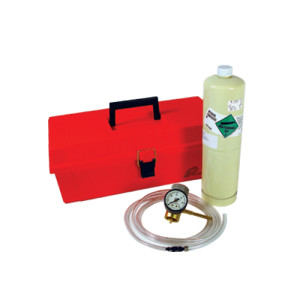 a red tool case next to a light‑colored cylinder and a loop of clear tubing with a small pressure gauge